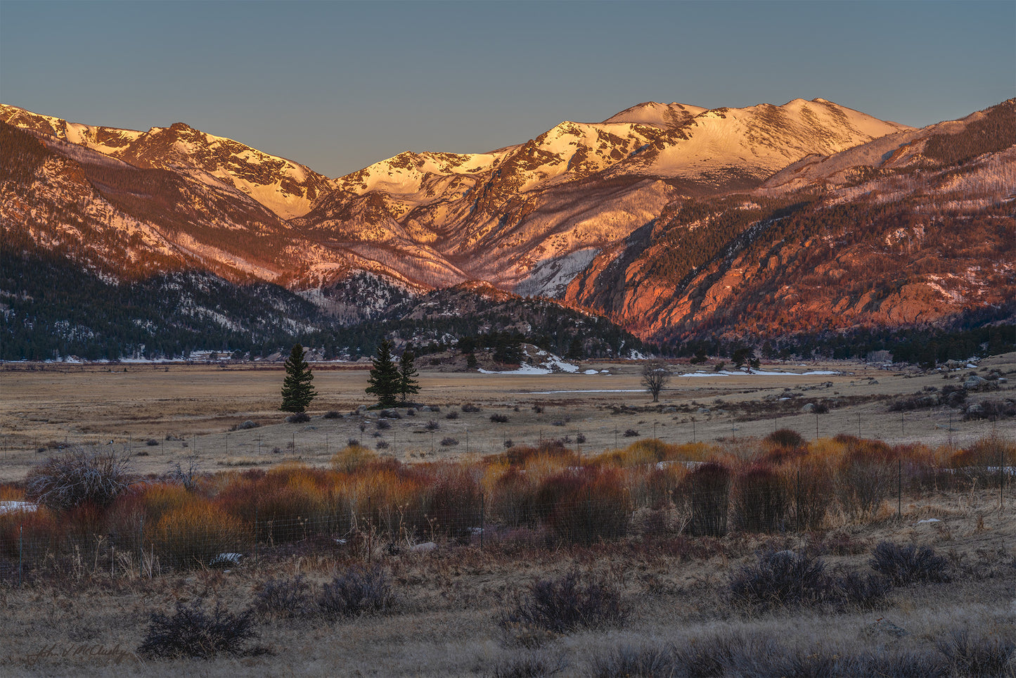The sunrise first hits the mountain peaks at Moraine Park in Rocky Mountain National Park. In this landscape photography print, I particularly love the way the willow buds in the foreground mirror the red rocks in the mountain, and how the morning light brings out the textures on the snowy mountains.