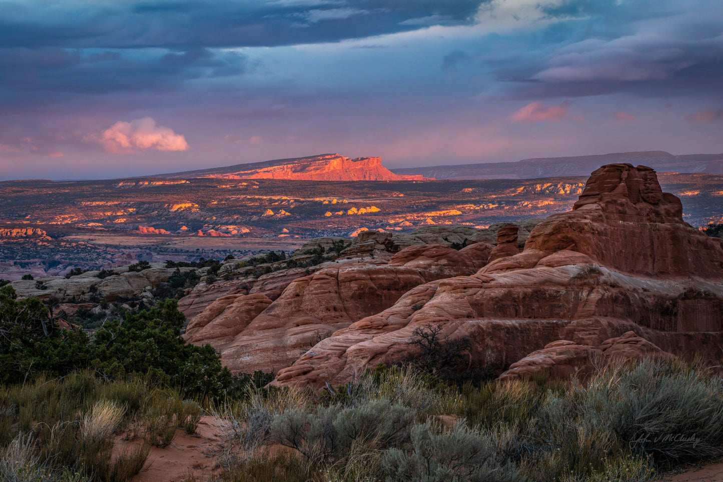 Sunset over a Canyonlands desert landscape with red rock formations