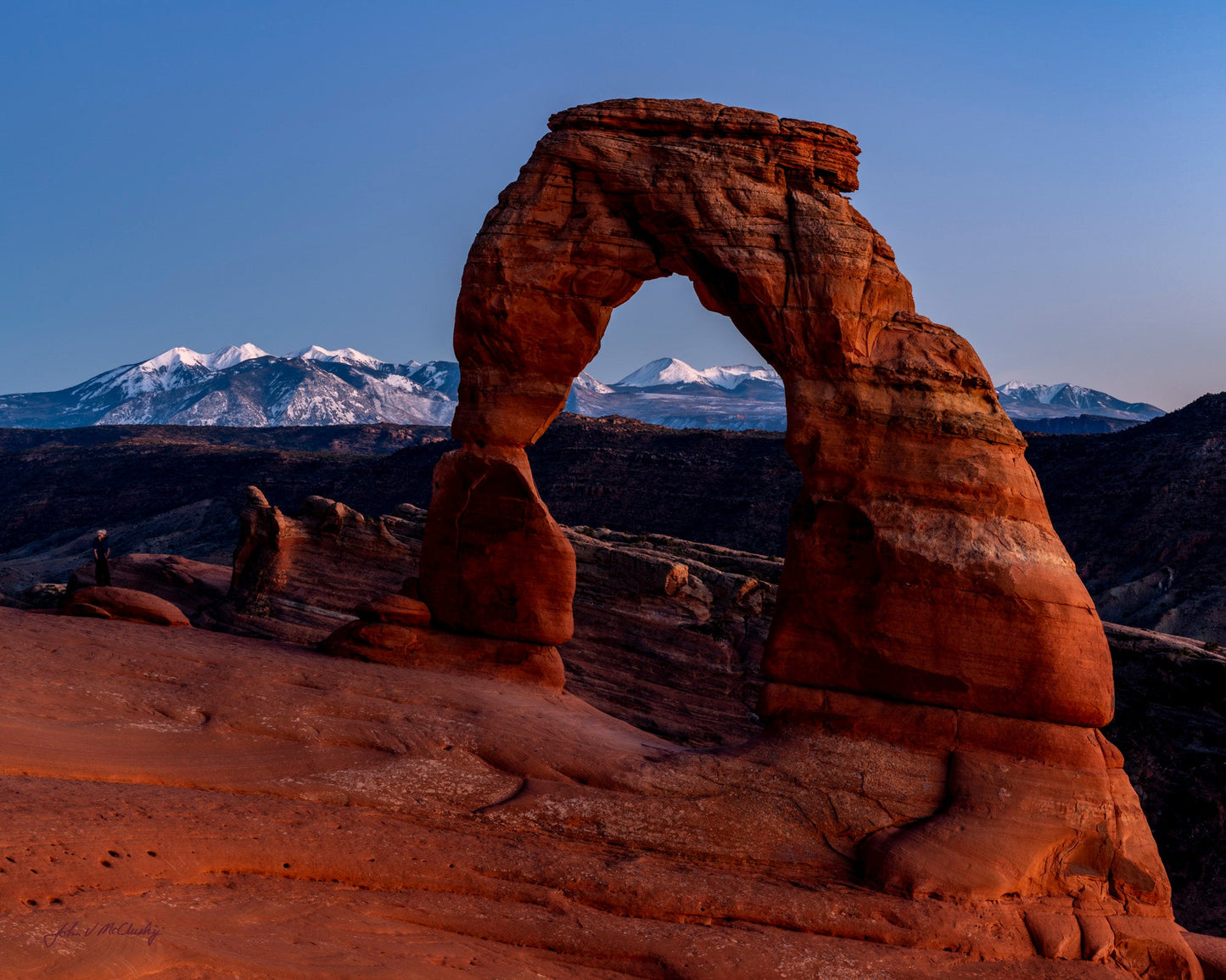 Delicate arch with snow-capped mountains in the background