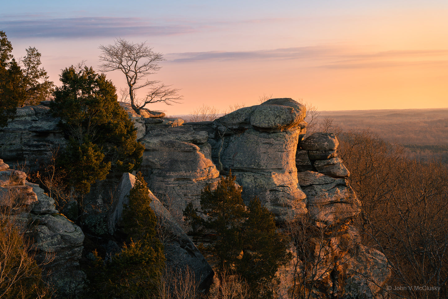 The last light of sunset reflects off the sandstone cliffs of Garden of the Gods, Illinois. The pastel sky and gently lit rolling woodlands grace the horizon in this landscape photography print by McClusky Nature Photography.