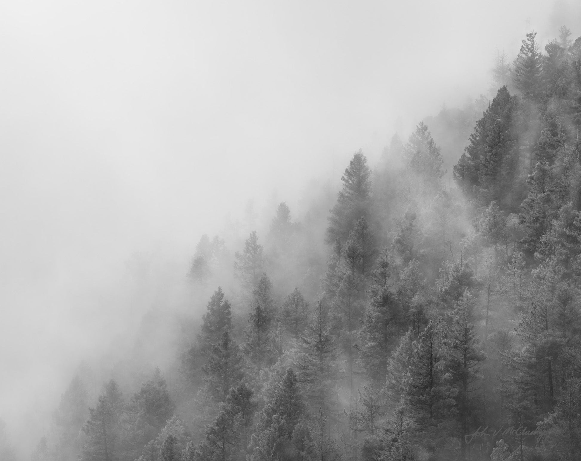 Clouds cascade over the mountain ridgeline.