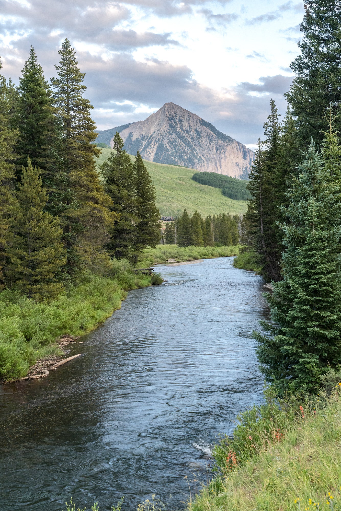 The Slate River in Crested Butte, Colorado is beautiful. I was struck by the trees framing the mountain and river, while the setting sun was just starting to color the clouds in this landscape photo.